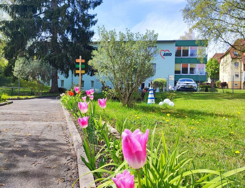 Ein großes Haus mit mehreren Etagen und Bluemn an den Balkonen