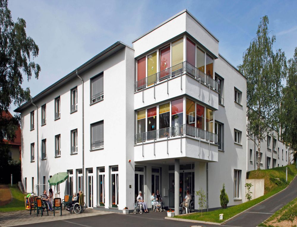 Ein großes Haus mit mehreren Etagen und Bluemn an den Balkonen