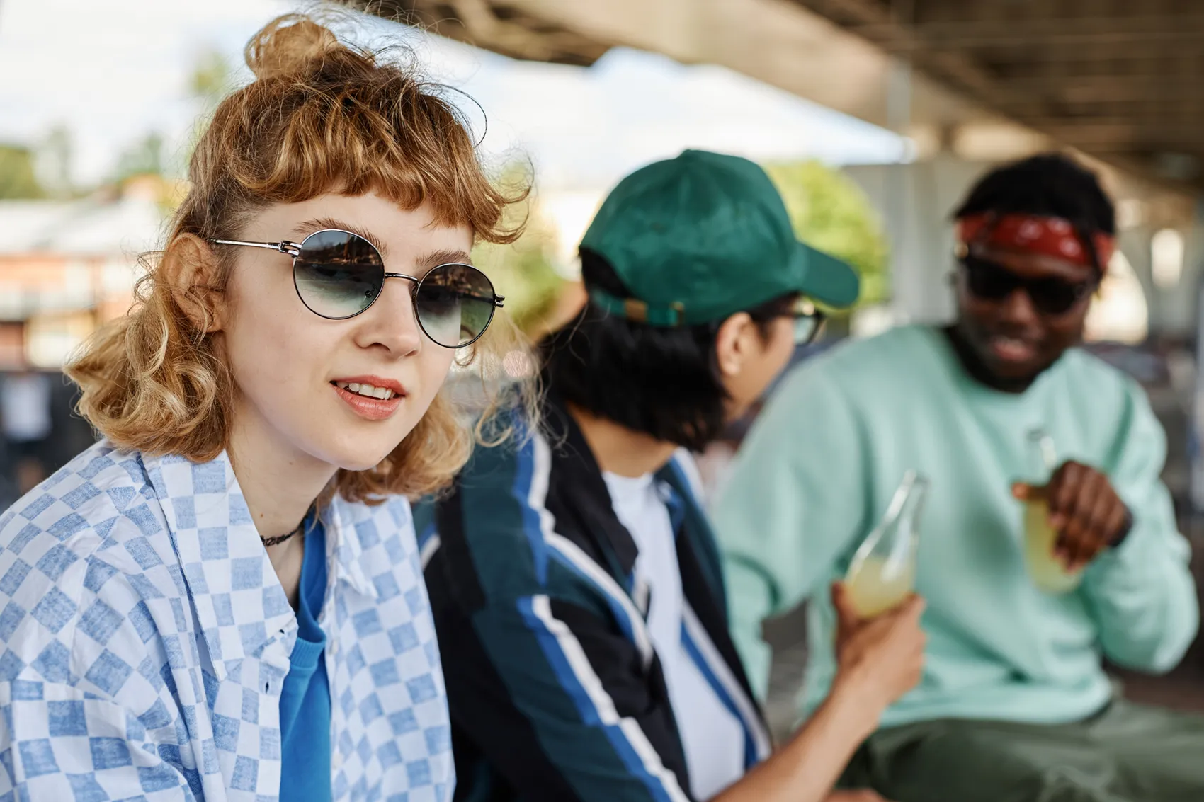 Eine junge Frau mit Sonnenbrille schaut in die Kamera.